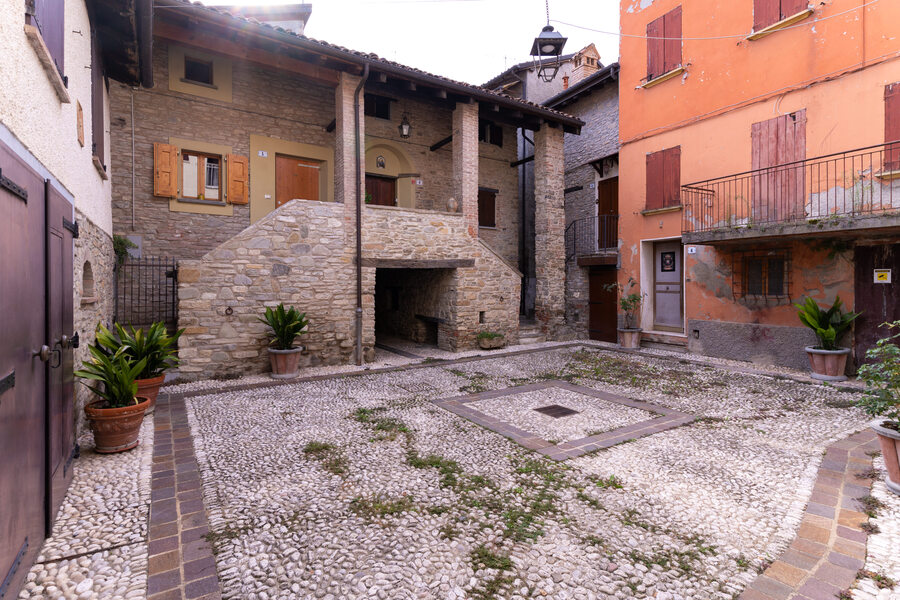 Piazzetta con pavimentazione in pietra e vecchia casa